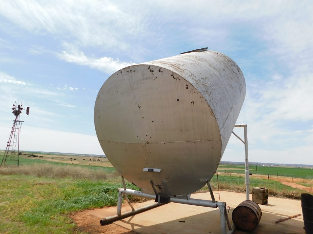 Grain Bin: 210- barrel slant bin made on skid being sold separately from the surface. 10’ wide x 16’ long x 20’ tall