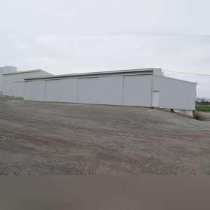 This building is 55â??x95â?? with a 16â??x36â?? lean-to off of the east side. It has a concrete floor, (3) 14â??x14â?? sliders, (3) walk-in doors, (7) 13â??x45â?? individual storage bays, and 220 amp single-phase electric.