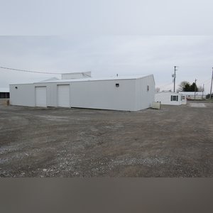 This 34â??x98â?? building includes a 34â??x45â?? shop area with overhead storage, concrete floor, Reznor natural-gas heating unit, 14â??x15â?? overhead door, and walk-in door. The remaining 34â??x53â?? area has a concrete floor, (3) 10.5â??x14â?? overhead doors, 9â?? slider, (2) walk-in doors, and 220 amp single-phase electric.