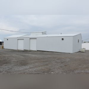 This 34â??x98â?? building includes a 34â??x45â?? shop area with overhead storage, concrete floor, Reznor natural-gas heating unit, 14â??x15â?? overhead door, and walk-in door. The remaining 34â??x53â?? area has a concrete floor, (3) 10.5â??x14â?? overhead doors, 9â?? slider, (2) walk-in doors, and 220 amp single-phase electric.