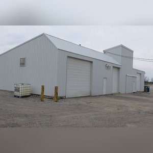 This 34â??x98â?? building includes a 34â??x45â?? shop area with overhead storage, concrete floor, Reznor natural-gas heating unit, 14â??x15â?? overhead door, and walk-in door. The remaining 34â??x53â?? area has a concrete floor, (3) 10.5â??x14â?? overhead doors, 9â?? slider, (2) walk-in doors, and 220 amp single-phase electric.