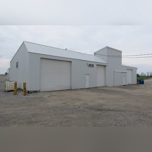 This 34â??x98â?? building includes a 34â??x45â?? shop area with overhead storage, concrete floor, Reznor natural-gas heating unit, 14â??x15â?? overhead door, and walk-in door. The remaining 34â??x53â?? area has a concrete floor, (3) 10.5â??x14â?? overhead doors, 9â?? slider, (2) walk-in doors, and 220 amp single-phase electric.