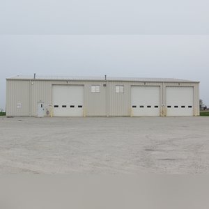 This steel-framed, completely insulated building boasts many custom features making it ideal for multiple purposes. It includes (3) office areas with built-in work surfaces, air conditioning, and LP gas forced-air heat. (2 offices are 12â??x11â?? & the other is 19â??x11â??.) The garage/shop area is 75â??x100â?? with concrete floors & approaches, (6) 16â??x16â?? overhead doors with openers, (4) walk-in doors, and loft storage area above offices. Additional amenities include (2) Reznor LP heaters, Energylogic waste oil furnace, ventilation system with louvered panels, ceiling fans, multiple electrical panels with 220 amp service, several outdoor electrical outlets with pigtail cords to plug in tractors, semis, etc., and a 10 HP 2-stage NAPA air compressor.